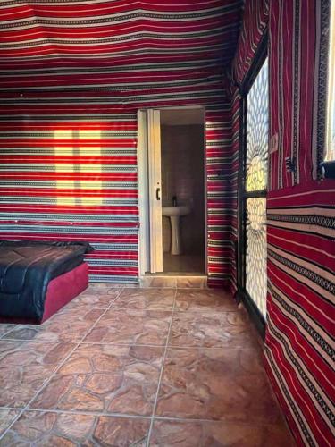 a room with a red and white striped wall at Dana Sunset camp in Nijil