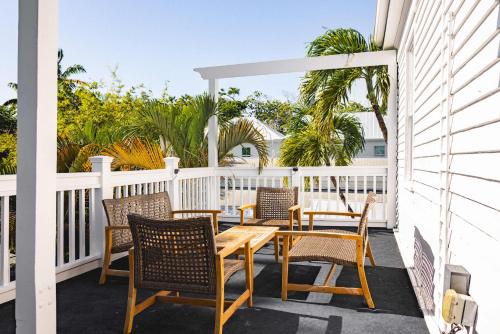 un patio avec une table et des chaises sur un porche dans l'établissement Key Lime Cottage, à Key West