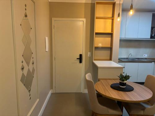 a small kitchen with a table and a door at Ravello Residencial, Perto do Centro e da Ponte da Amizade in Foz do Iguaçu
