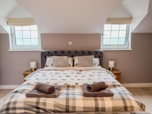 a bedroom with a bed with two towels on it at Tollbar Cottage in Penrith