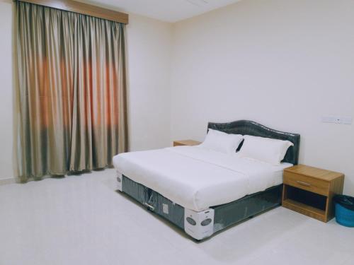 a bedroom with a large bed with a window at هومي 2 in Salalah