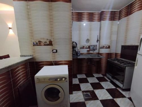 a washing machine in a kitchen with a checkered floor at Mayane guesthouse in Luxor