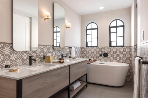 a bathroom with two sinks and a tub and a bath tub at Casa Cleo by Viadora in Mexico City