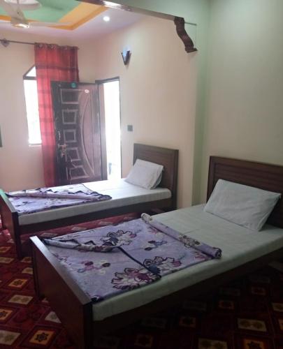 a room with two beds in a room at Balakot International Hotel in Dargai