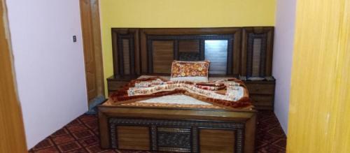 a bedroom with a wooden bed and a mirror at Balakot International Hotel in Dargai
