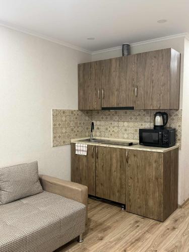 a kitchen with wooden cabinets and a couch in a room at Apartment N111 Loft 2 in Gudauri