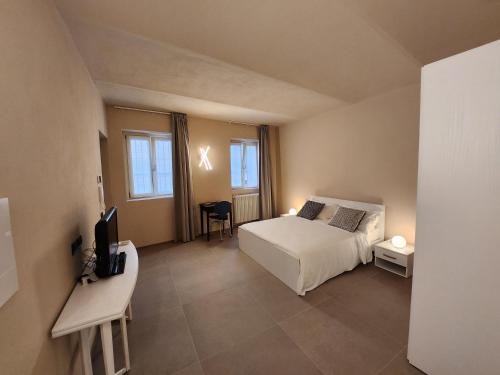 a bedroom with a bed and a desk and a television at CA' 'D Ricardo in Alba