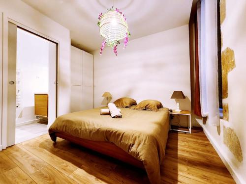 a bedroom with a bed and a chandelier at Flor de Lys - Centre historique in Auch