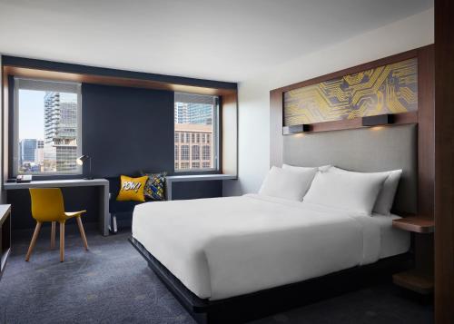 a bedroom with a large white bed and a desk at Aloft by Marriott Atlanta Downtown in Atlanta