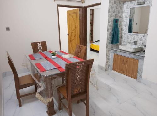 ein Esszimmer mit Tisch, Stühlen und Spüle in der Unterkunft Haven Apartment in Dhaka