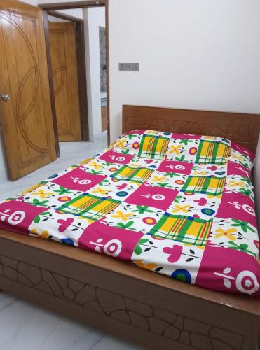 ein Bett mit einer bunten Decke darauf in der Unterkunft Haven Apartment in Dhaka