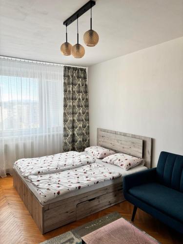 a bedroom with a bed and a blue couch at SimpleStay with parking in Košice