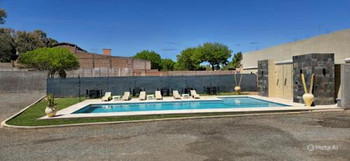 a swimming pool with lounge chairs and a building at Cuesta de Miranda 2 in Villa Unión