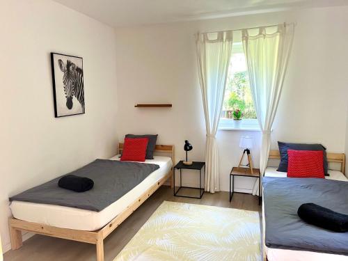 Un dormitorio con dos camas y una ventana. en Wildrose holiday home, en Badacsonytomaj