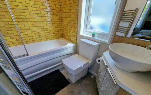 a bathroom with a tub and a toilet and a sink at The View Point Northumberland in Newton on the Moor