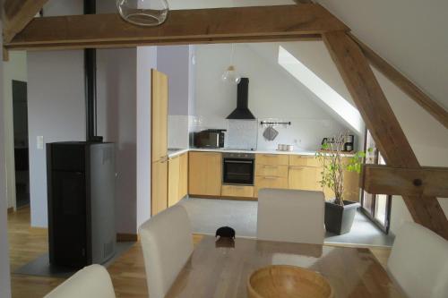 cocina grande con nevera negra y armarios de madera en Gite de la Cure Gourmande, en Saint-Christophe
