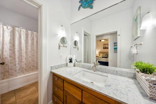 Un baño con lavabo y un espejo grande. en Condos in Kiahuna Plantation, en Koloa