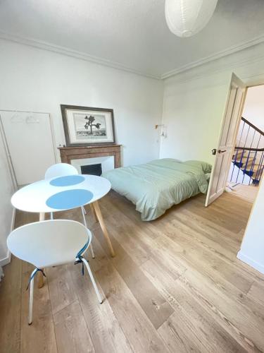 een slaapkamer met een bed, een tafel en stoelen bij Studio au cœur de Chabeuil in Chabeuil