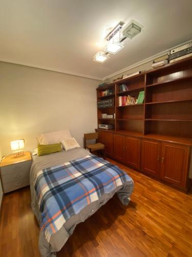 a bedroom with a bed and a book shelf at HomeOffice with Church Views in Zumárraga