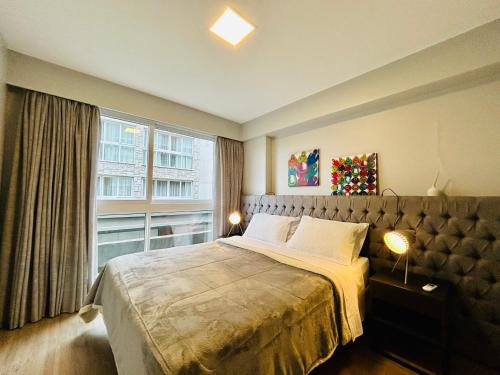 a bedroom with a large bed and a window at Vita Boulevard Gramado in Gramado