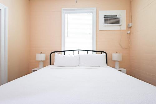 a bedroom with a white bed with two lamps at Creme Brulee Suite in Key West