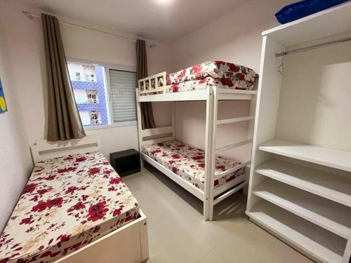 a bedroom with two bunk beds and a bed at Apto Praia das Toninhas in Ubatuba