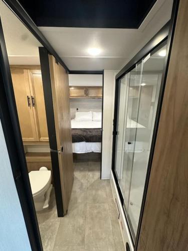 a small bathroom with a toilet and a bed at Buffalo Drift Tiny Home in Interior