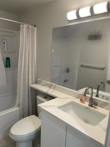 a white bathroom with a sink and a toilet at Dunique unique home in Winnipeg