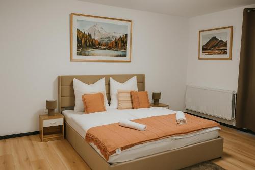 a bedroom with a bed with orange and white pillows at Zentrumsnahe Wohnung mit Blick auf Siegens Obere Schloss in Siegen