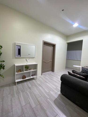 a living room with a couch and a tv on a wall at فيلا وشاليه الجبل الاحمر in AlUla