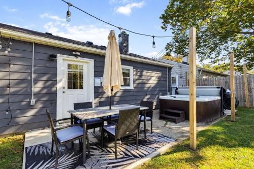 een patio met een tafel en stoelen en een bad bij 2BR with Private Hot Tub in Parma Heights