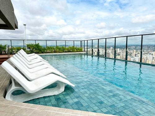 a white lounge chair sitting on top of a swimming pool at STAY ID Vida Urbana in Goiânia