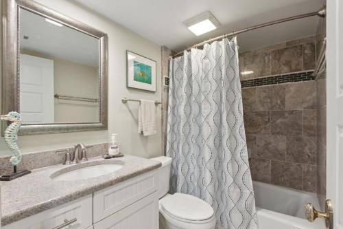 a bathroom with a sink and a toilet and a shower at Beautiful Corner Oceanfront 2-bedroom, 2 bath Condo in Amelia Surf & Racquet in Amelia Island