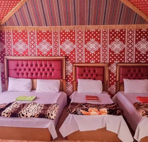 a room with two beds and a wall with patterns at Rum jeep in Wadi Rum