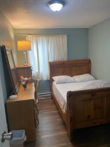 a bedroom with a bed and a table with a lamp at Comfy Private Room in Brampton