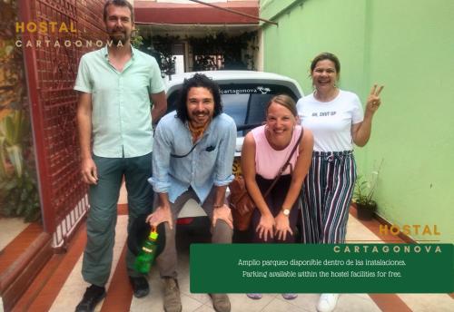 Un groupe de personnes debout devant une voiture dans l'établissement Hostal Cartagonova - Habitaciones privadas y amplias cerca a zonas turísticas, à Carthagène des Indes