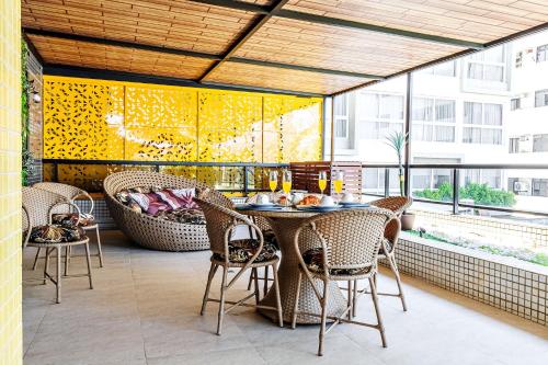 an outdoor patio with a table and chairs at Flat espaçoso, no Manaíra, com varanda ampla, a 100m da praia e ao lado do Mag Shopping in João Pessoa