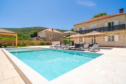 a swimming pool with chairs and a building at Villa MarLea in Dubrovnik