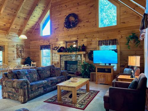 a living room with a couch and a television at 6BR close to PF Parkway- 2 hot tubs, game room, 4 decks, 3 living areas! in Pigeon Forge
