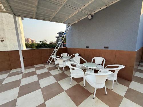 a patio with tables and chairs and a ladder at Rasa Boutique Stay in Greater Noida