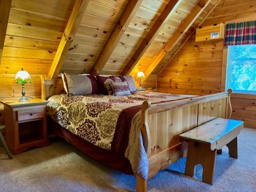 a bedroom with a bed in a log cabin at 6BR close to PF Parkway- 2 hot tubs, game room, 4 decks, 3 living areas! in Pigeon Forge