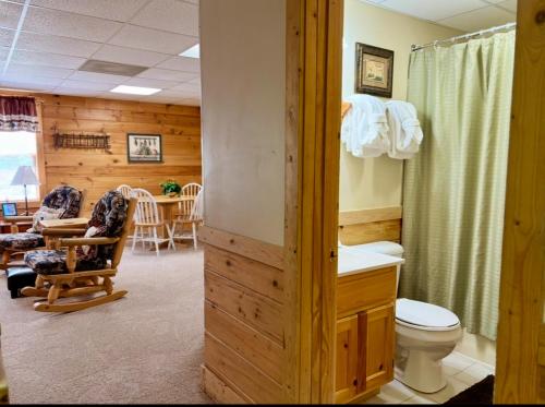 a bathroom with a toilet and a dining room at 6BR close to PF Parkway- 2 hot tubs, game room, 4 decks, 3 living areas! in Pigeon Forge
