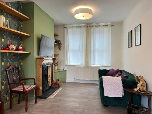 sala de estar con sofá verde y chimenea en Hartoft House, 3 Bed, Near River and City, en York