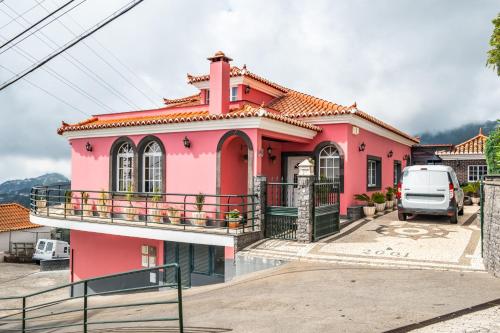 a pink house with a balcony in a parking lot at Ocean Hill View By Zest&Guest in Câmara de Lobos