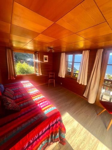a bedroom with a bed in a room with windows at Ferienwohnung im Kräuterhaus Albinen in Albinen