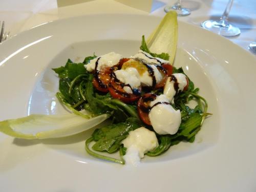 a plate of food with a salad on a table at Hotel am Rosengarten in Bad Wimpfen