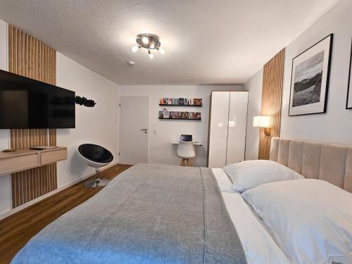una camera da letto con un letto grande e una TV a schermo piatto di Inn-Side Rottweil a Rottweil