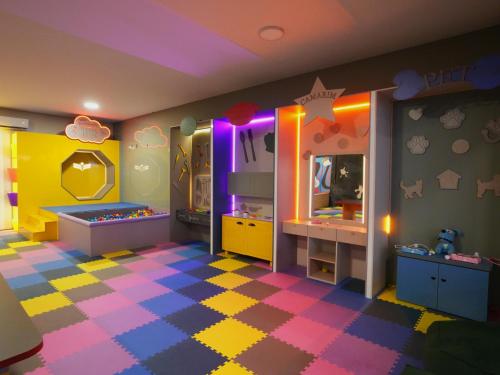 a childs room with a colorful floor and a bedroom at Morro dos Anjos Águas Quentes Hotel Resort in Bandeirantes