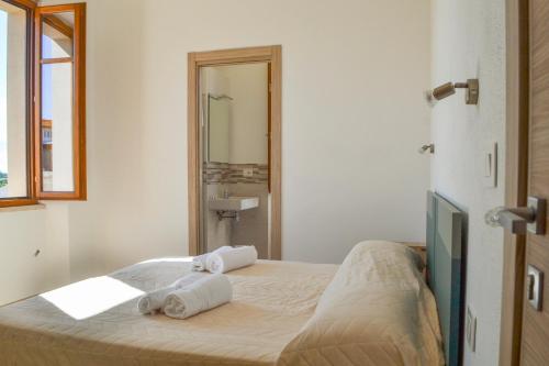 una camera da letto con un letto con due asciugamani sopra di La Piazzetta Affittacamere a Ghilarza