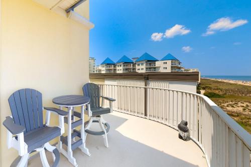 a balcony with two chairs and a table and a house at Adagio 501 in Ocean City